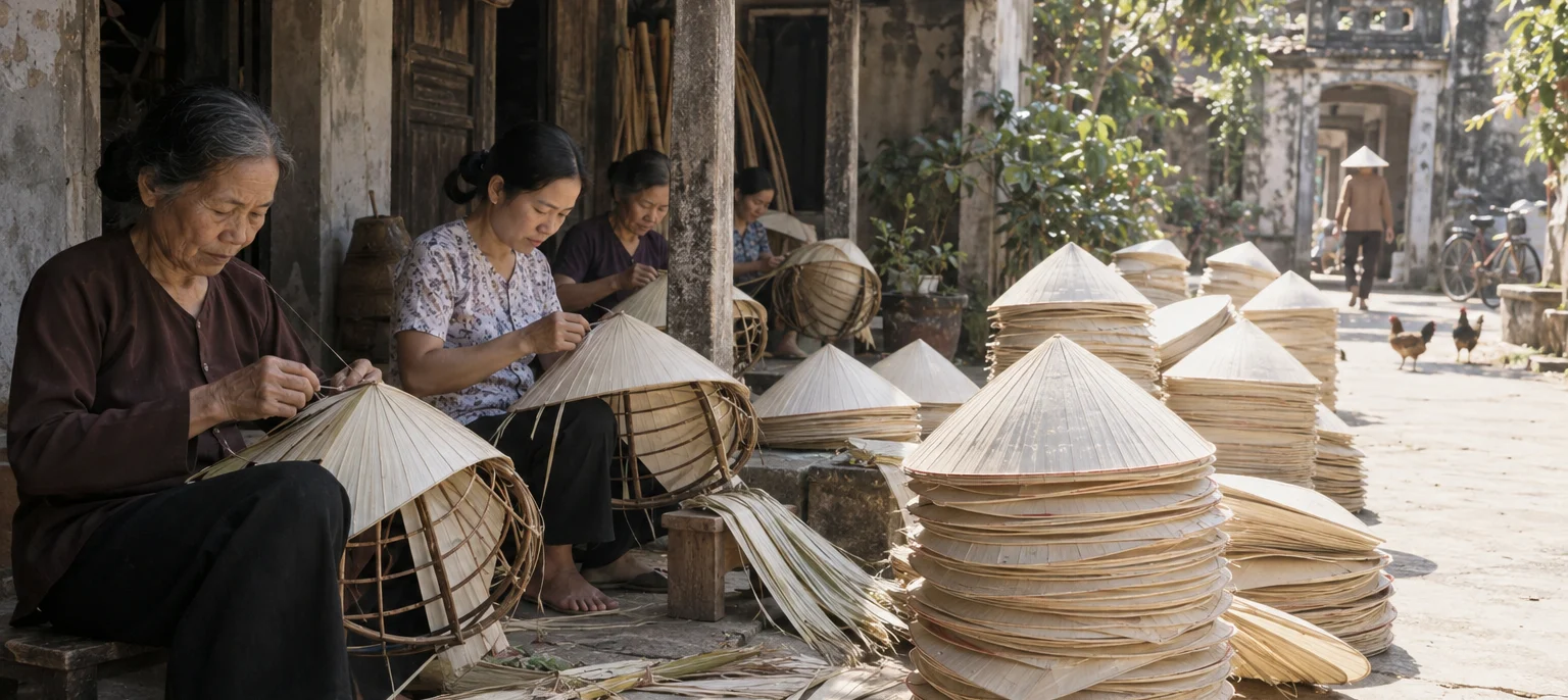 Women in Chuông village stitching conical palm-leaf hats on bamboo frames, finished hats stacked in a sunlit yard, Chuông village, Red River Delta, Vietnam